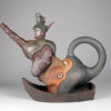 A teapot with a gnome on top of it.