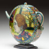 A teapot with a painting of a woman on it.