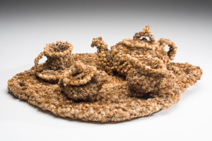 A crocheted tea set on a round mat.