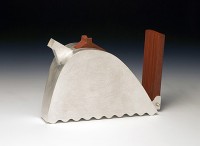 A metal teapot with wooden handle and base.