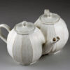 A white teapot and tea pot sitting on top of a table.