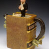 A small statue of a man on top of a book.