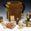 A collection of figurines and money are next to an old book.
