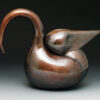 A bronze bird sculpture sitting on top of a floor.
