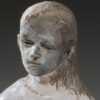 A statue of a woman with long hair and a sad face.