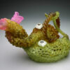 A green object with pink flowers and white eyes.