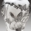 A vase with black and white drawings on it.