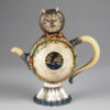 A teapot with a cat face on it.