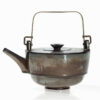 A tea pot with a handle and lid.