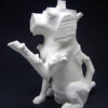 A white dog sculpture sitting on top of a black surface.