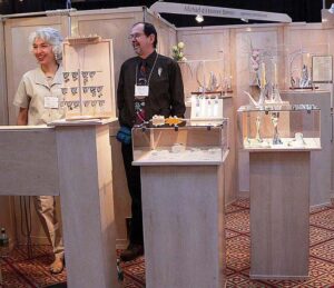 A couple of people standing in front of some vases.