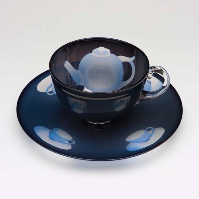 Ann Wolff. Glass cup and saucer with teapot imagery.